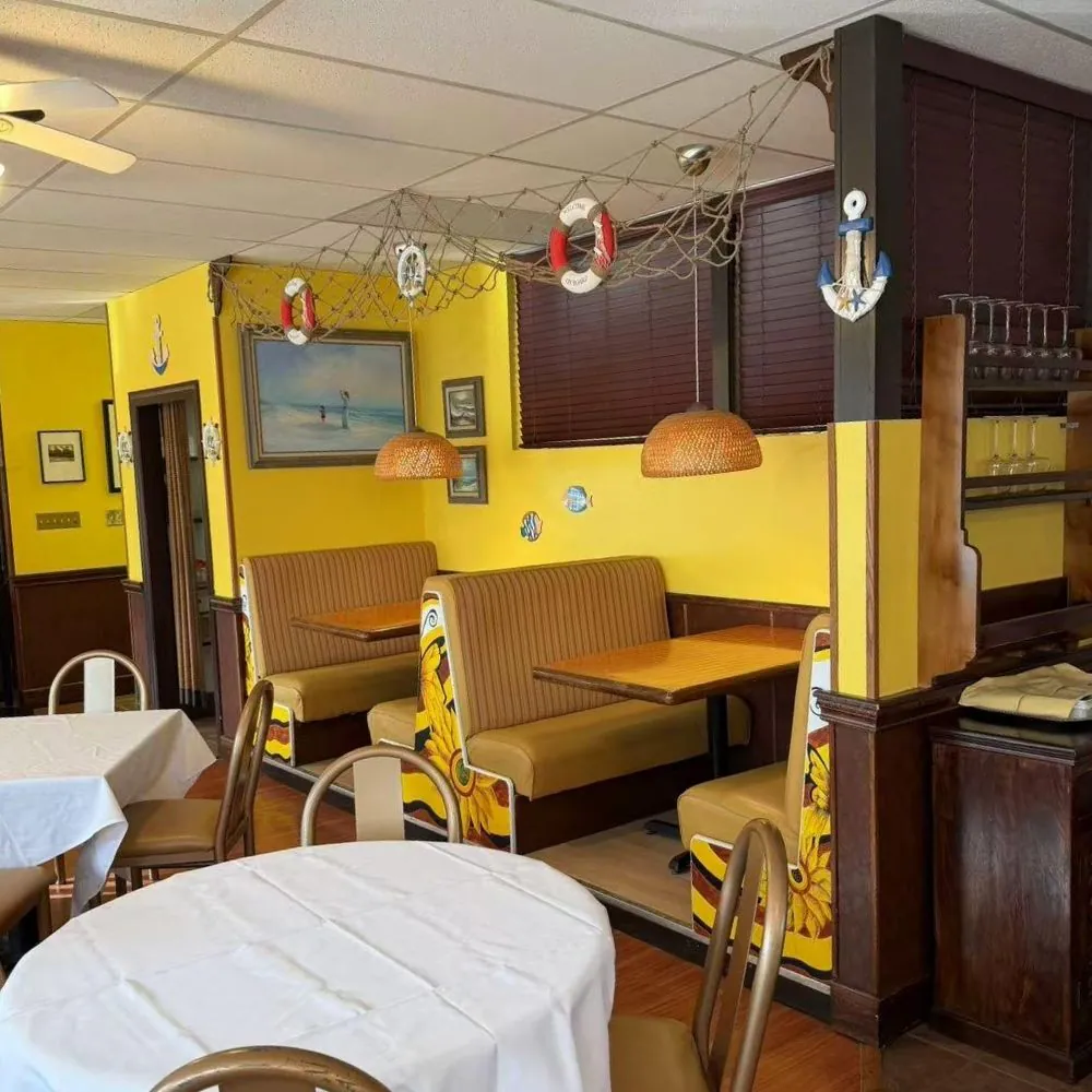 Yellow-walled dining space with booths, art and nautical decor at Eraka Sushi, a Japanese Restaurant in Easton