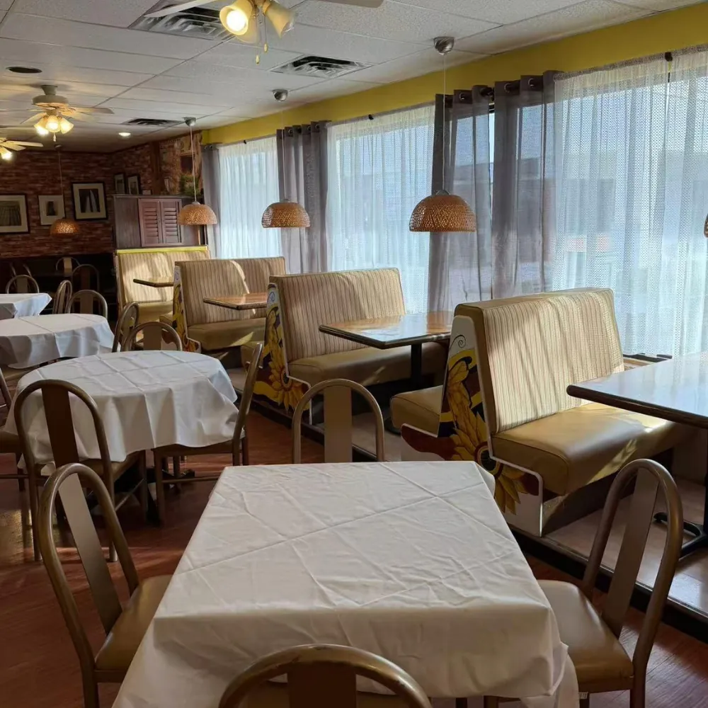 Dining room with tables and sunflower booths at Eraka Sushi, a Japanese Restaurant in Easton